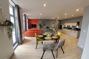 a dining room and living room with a table and chairs at Appartement Le palais autun in Autun