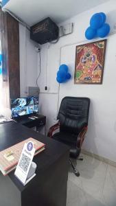 oficina con escritorio y silla con globos azules en Laxmi Dormitory, en Vrindāvan