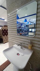 a bathroom with a white sink and a mirror at Laxmi Dormitory in Vrindāvan