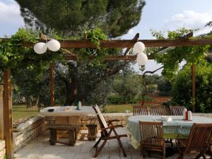 un patio con mesa y sillas bajo una pérgola en Autentica Masseria Pugliese, en Putignano