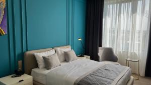 a bedroom with a bed and a blue wall at Bentley Hotel Tashkent in Tashkent +29 photos