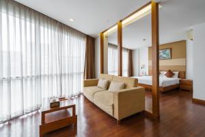 a living room with a couch and a bed at Lantana Resort Hotel Bangkok in Bangkok