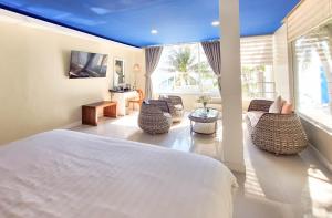 a bedroom with a large bed and a living room at Boracay Ocean Club Beach Resort in Boracay