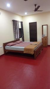 1 dormitorio con 1 cama y alfombra roja en CANALVIEW PRIVATE COTTAGE Azhikkal Ayiram Thengu, en Panmana