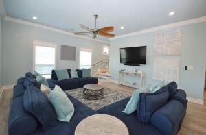 uma sala de estar com um sofá azul e uma televisão de ecrã plano em Beach Sands 1 New Build Private Pool-Hut Tub em Bolivar Peninsula