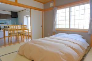 1 dormitorio con 1 cama blanca grande en una habitación en ノースメゾンbiei大町 en Biei