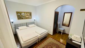 a bedroom with a white bed and a mirror at Samarkand Travel Hotel in Samarkand