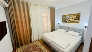 a bedroom with a white bed and a window at Samarkand Travel Hotel in Samarkand