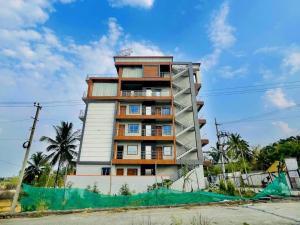 a tall apartment building on the side of a street at Dhruva Sky villament in Bidadi