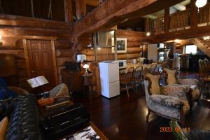 a living room filled with furniture and a white refrigerator at Pension Prussian Blue in Miyako Island