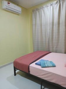 een bed in een kamer met een raam bij Homestay FarHaA in Tanah Merah