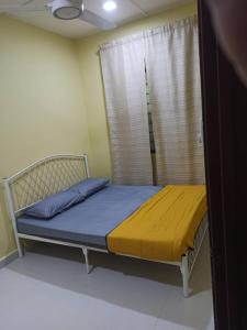 een klein bed in een kamer met een raam bij Homestay FarHaA in Tanah Merah