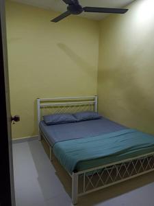 een slaapkamer met een bed en een plafondventilator bij Homestay FarHaA in Tanah Merah