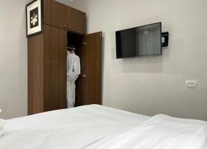 - une chambre avec un lit et une télévision dans un placard dans l'établissement FRODO, à Tachkent