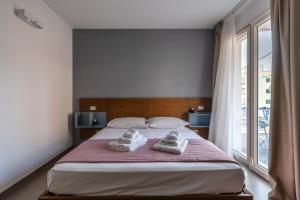 a bedroom with a large bed with two towels on it at Serafini Rooms in Noto