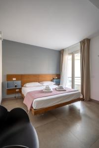 a bedroom with a large bed and a large window at Serafini Rooms in Noto