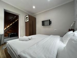 タシュケントにあるFRОDО - Cozy as a home for 2-5 personsのベッドルーム(白いベッド2台、テレビ付)