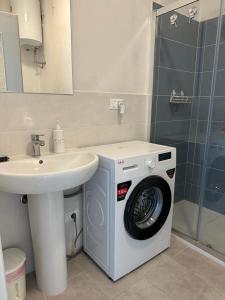 ein Badezimmer mit einer Waschmaschine und einem Waschbecken in der Unterkunft Vista Bella House in Sanremo