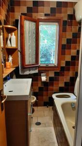 bagno con lavandino, servizi igienici e finestra di Villa roverella a Cassano delle Murge