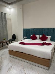 a bedroom with a large bed with red pillows at Hotel Sundram in Zirakpur