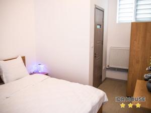 a bedroom with a white bed and a window at IDR HOUSE in Buzău