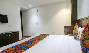 a bedroom with a bed with a colorful blanket on it at FabExpress RG Stay in New Delhi