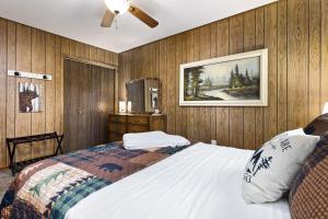 a bedroom with a bed and a painting on the wall at Autumn Mountain Vacations - Book Now! Rogue Bear Cabin in Williams
