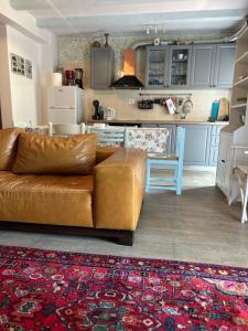 uma sala de estar com um sofá castanho e uma cozinha em Bonvivan House em Diminići