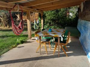 einen Tisch und Stühle auf einer Terrasse mit Hängematte in der Unterkunft Zielony Domek Plutycze in Plutycze