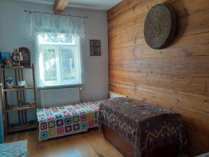Zimmer mit einer Bank und einer Holzwand in der Unterkunft Zielony Domek Plutycze in Plutycze