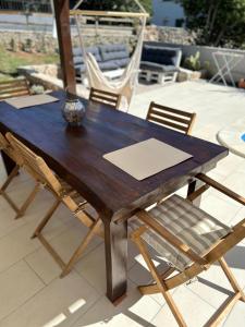 a wooden table and chairs on a patio at Bonvivan House in Diminići