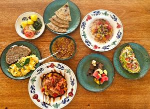 a group of plates of food on a wooden table at The Garden in Paje