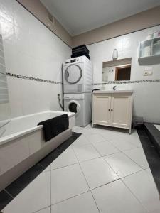 a white bathroom with a sink and a washing machine at Apartamento Cantabrico vistas a la Ría deRibadeo in Ribadeo