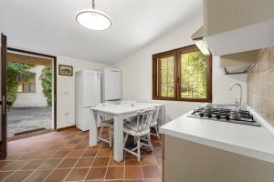 una cucina con piano di lavoro bianco e tavolo di Maria Maddalena 3 - for families a Iglesias