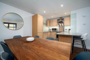 a kitchen and dining room with a wooden table and chairs at Modern & Spacious 2 Bedroom in Central London in London