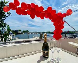 a bottle of champagne and two wine glasses on a balcony at COZY CONDO OCEAN 3xDECK YACHT in Brooklyn