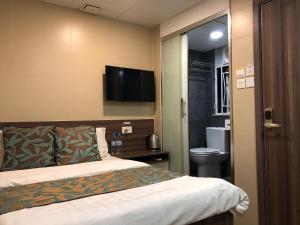 a hotel room with a bed and a flat screen tv at 香港星星旅馆 b&b in Hong Kong