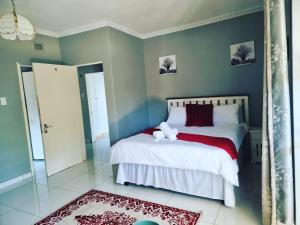 1 dormitorio con 1 cama con manta roja y blanca en Leading Guest Farm en Margate