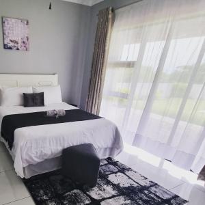 Un dormitorio con una cama grande y una ventana en Leading Guest Farm en Margate