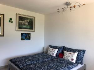 ein Schlafzimmer mit einem Bett und ein Bild eines Pferdes an der Wand in der Unterkunft Ferienwohnung mit wunderschöne Aussicht, Whirlpool und Sauna in Gordola