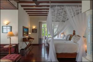 a bedroom with a white bed with a canopy at The Luang Say Residence in Luang Prabang