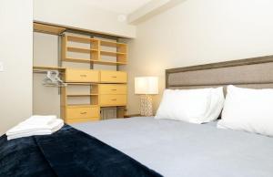 a bedroom with a large white bed and a dresser at Cozy apartment with amazing view in Calgary