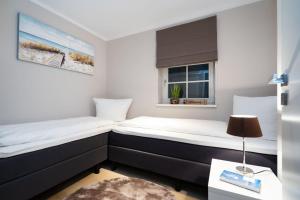 2 camas en una habitación pequeña con ventana en Haus-Wolfgang-Ferienwohnung-Anetta-01, en Westerland