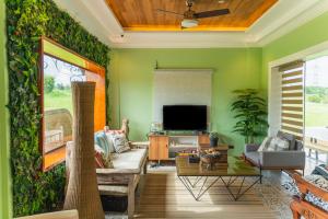 ein Wohnzimmer mit einer grünen Wand in der Unterkunft La Casa Tagaytay in Tagaytay