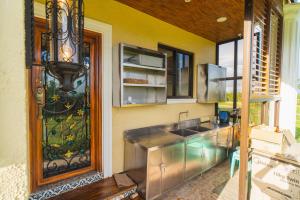 eine Küche mit Spüle und Glastür in der Unterkunft La Casa Tagaytay in Tagaytay