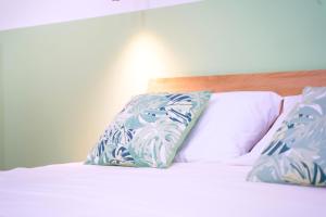 a bed with blue and white pillows on it at Suite N.1 [500mt da Policlinico/10min da Stazione] in Bari