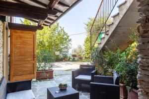 an outdoor patio with chairs and a wooden door at La Casa di Kati in Pietrasanta