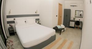 sypialnia z dużym białym łóżkiem i biurkiem w obiekcie My House w mieście Vashafaru