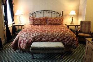 a bedroom with a bed and a chair and lamps at Beaumont Hotel and Spa - Adults Only in Ouray