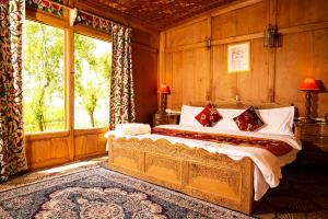 a bedroom with a bed and a large window at Golden Flower Heritage Houseboat in Srinagar